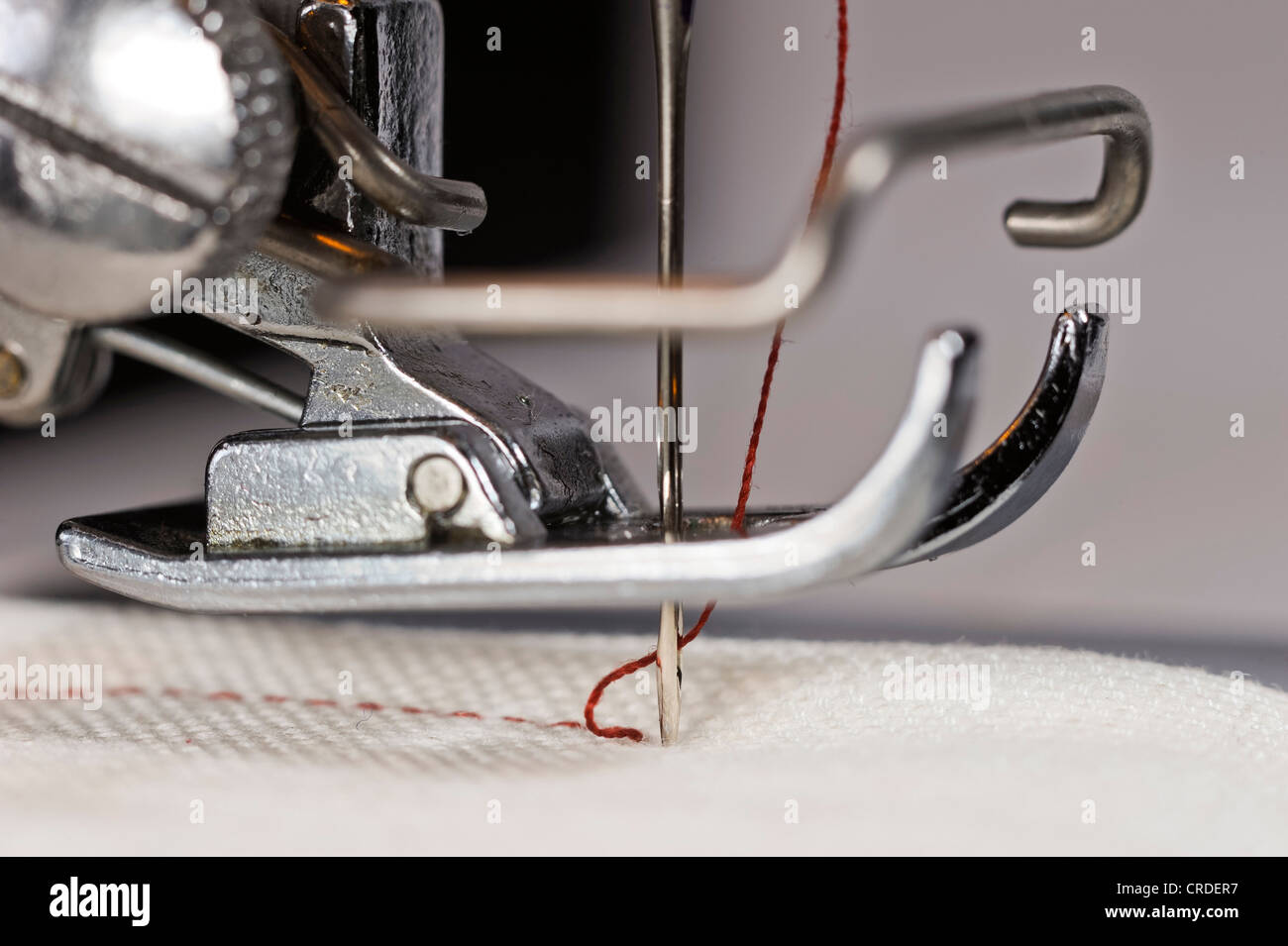 Sewing machine with presser foot and needle plate, red thread, white