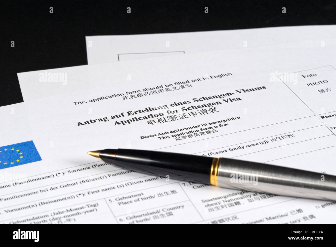 Application for a Schengen visa in German and Chinese, with pen Stock Photo
