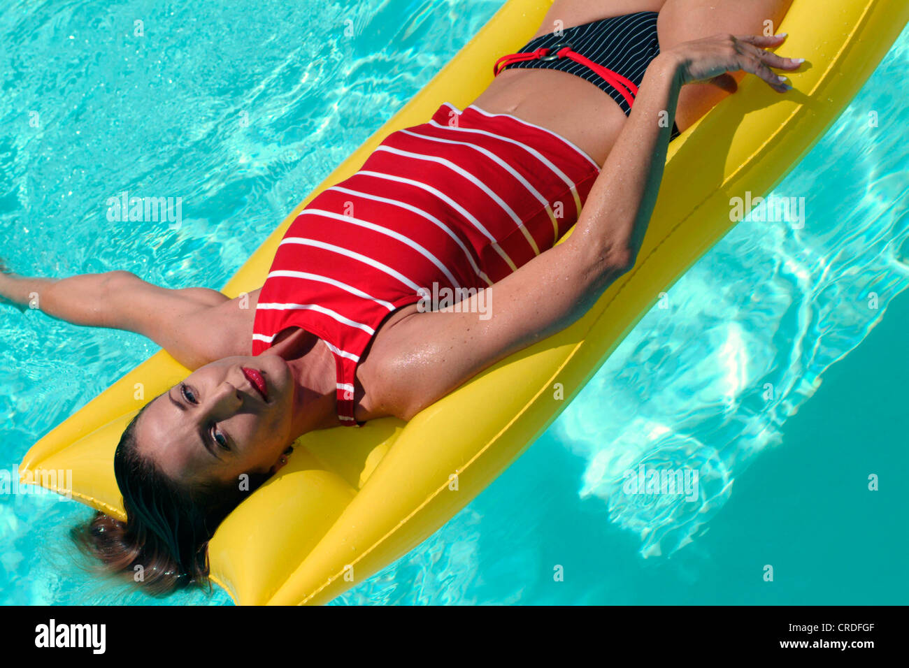 woman lying on an air mattress in a swimming pool Stock Photo