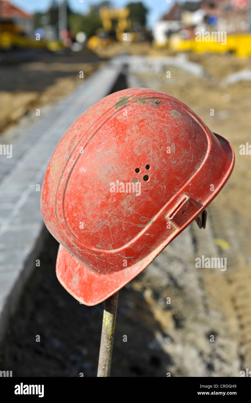 Red hard hat on an iron rod Stock Photo