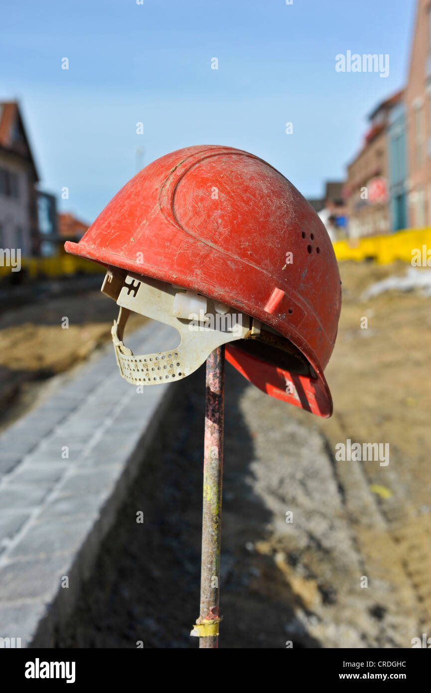 Red hard hat on an iron rod Stock Photo