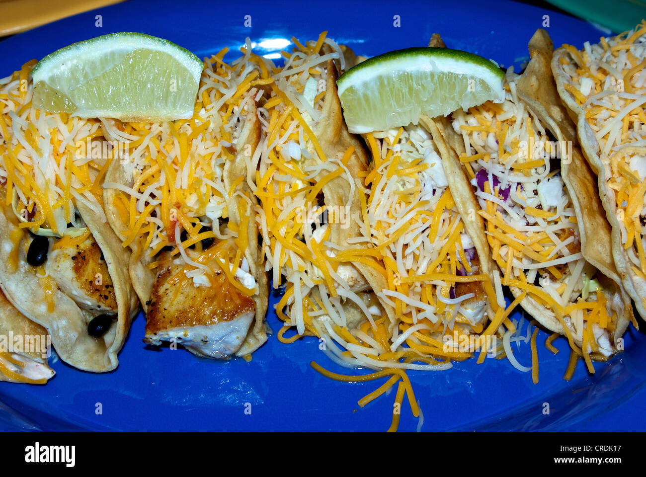 Platter fish tacos grated cheese olive topping lime wedges Stock Photo