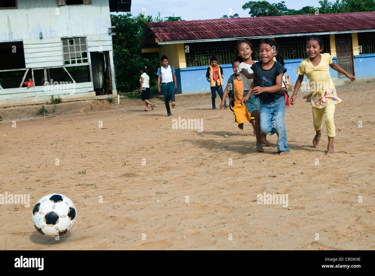 School children playing soccer in the schoolyard before classes start in a village with no road access in the rainforest of the Stock Photo