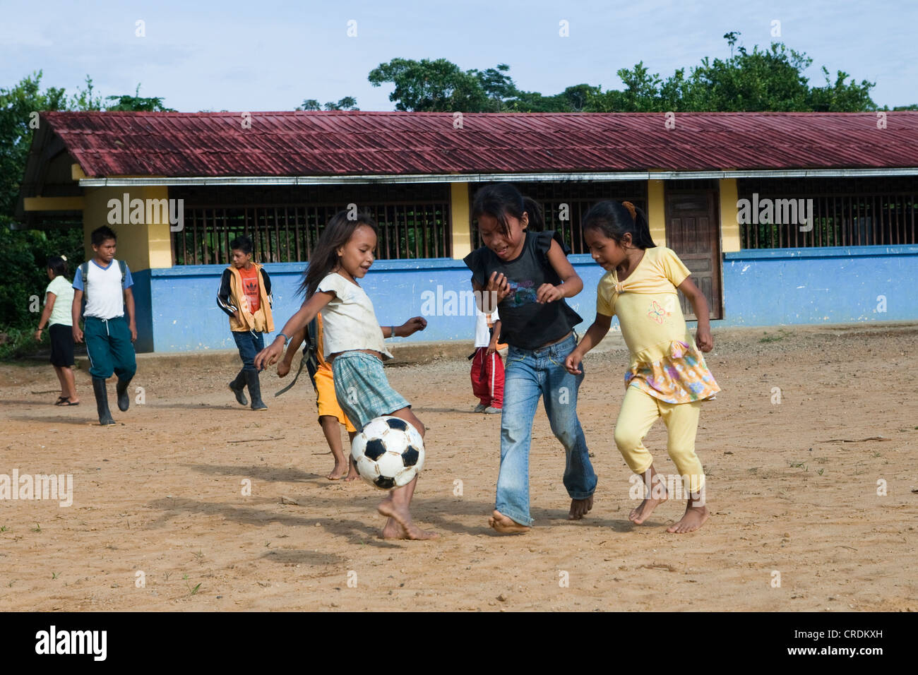 School children playing soccer in the schoolyard before classes start in a village with no road access in the rainforest of the Stock Photo