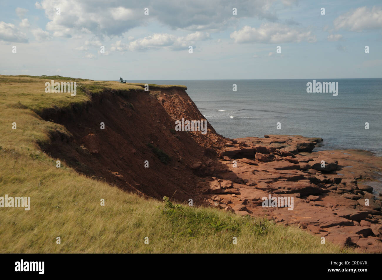 A chair sits atop the red cliffs in Hermanville, Prince Edward Island, Canada. Stock Photo