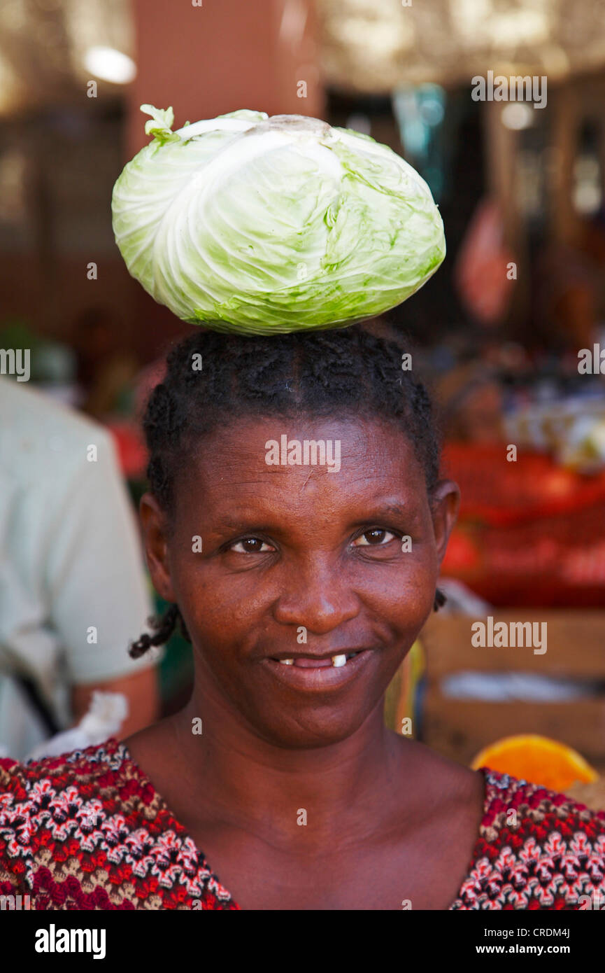 at the market; woman carrying cabbage on her head, Cap Verde Islands, Cabo Verde, Fogo, Sao Filipe Stock Photo