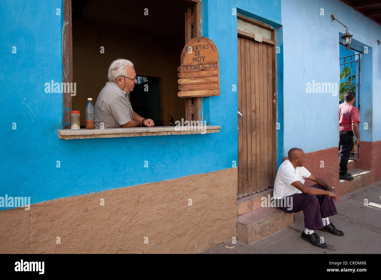 Man selling food from window in Trinidad, Cuba. Stock Photo