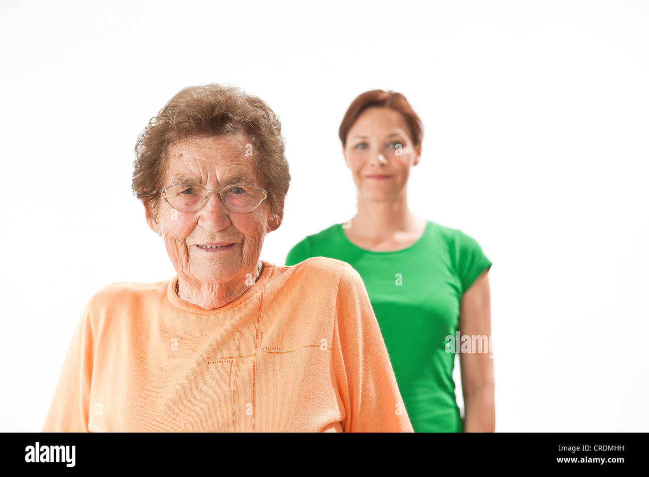 Smiling young woman standing behind an older woman Stock Photo - Alamy