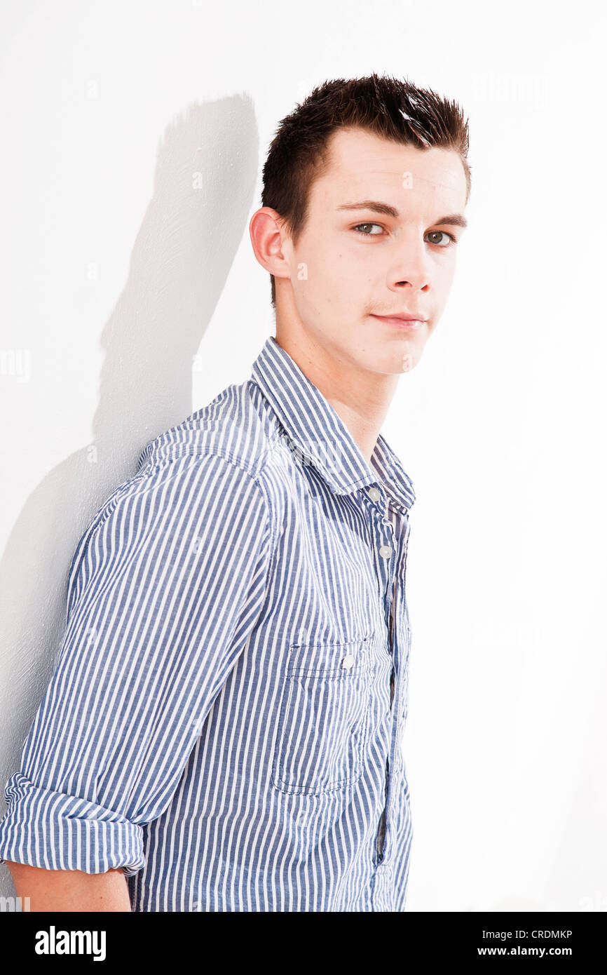 Young man leaning against a wall Stock Photo - Alamy