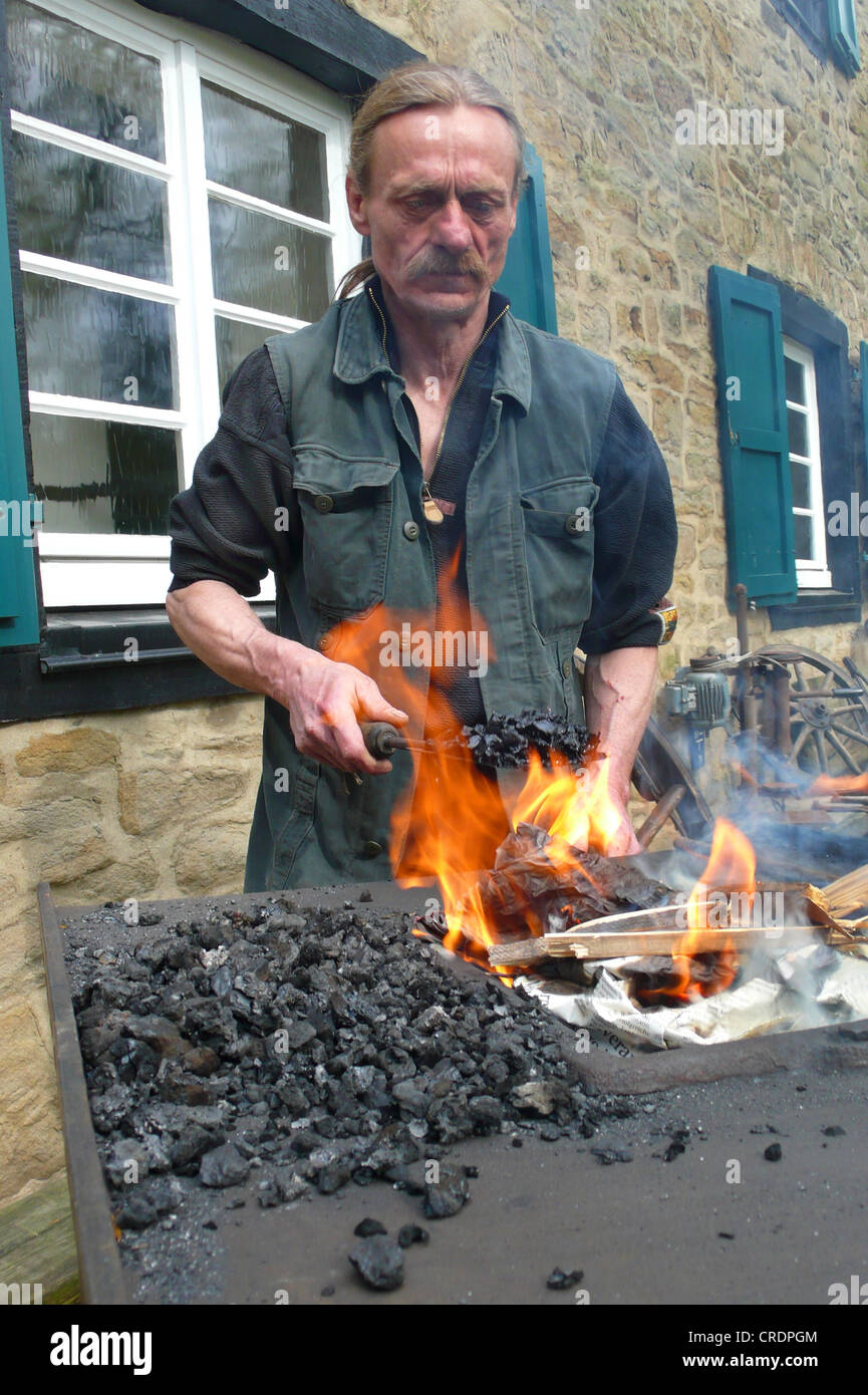 traditional handcraft, smith at work start a fire, Germany Stock Photo