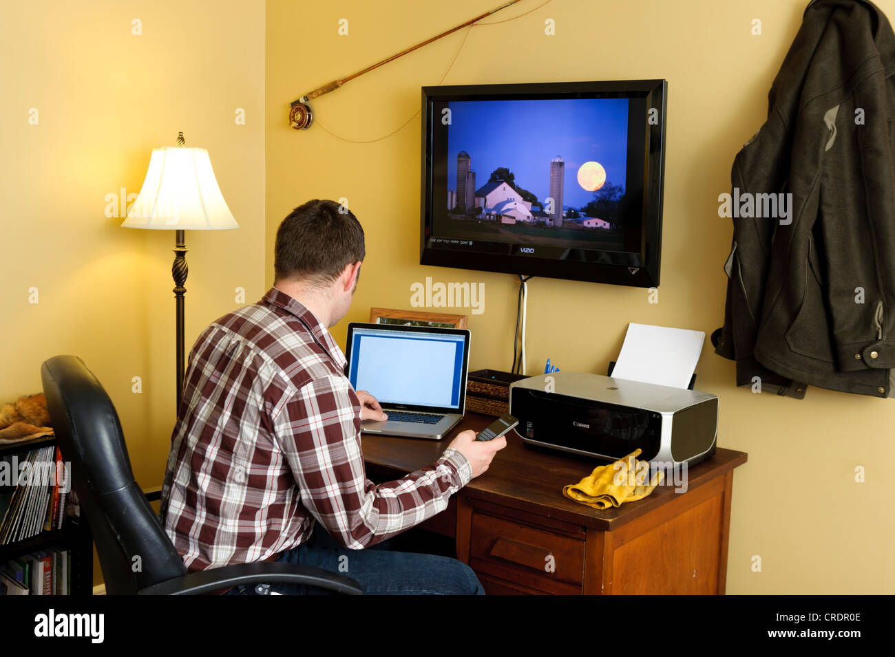 FARMER IN HOME OFFICE USING LAPTOP COMPUTER; WORKING FROM HOME Stock