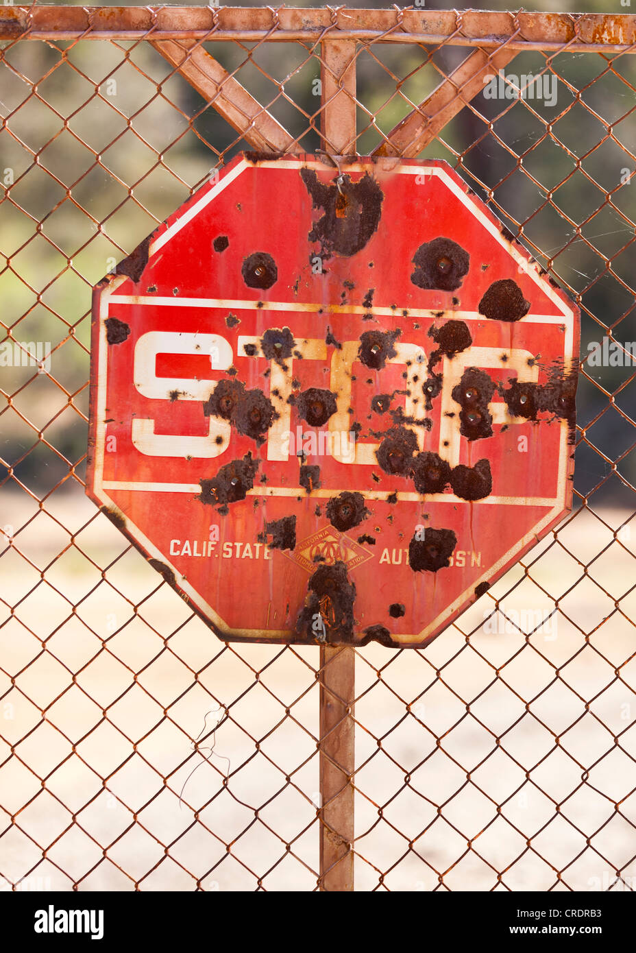Rusty stop sign with bullet holes Stock Photo