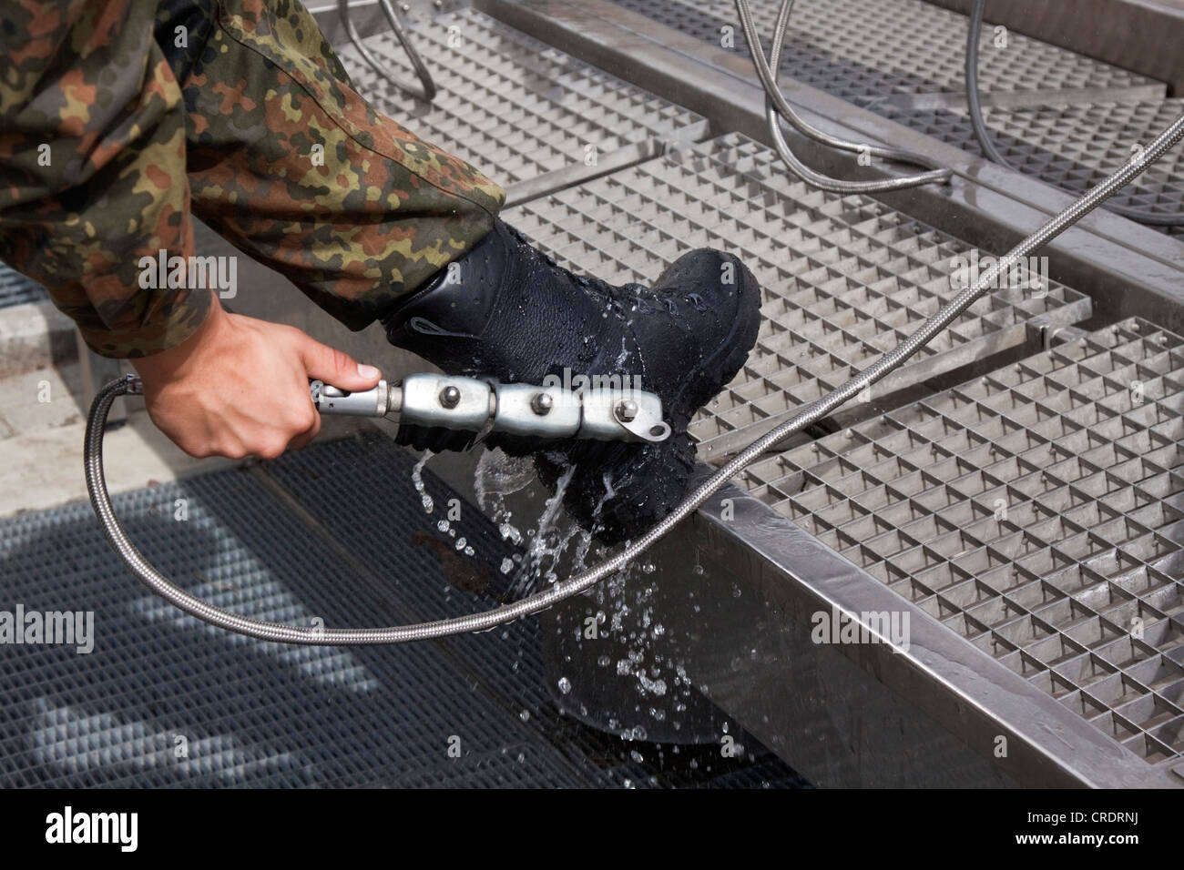 Cleaning army boots with a shoe brush and water Stock Photo