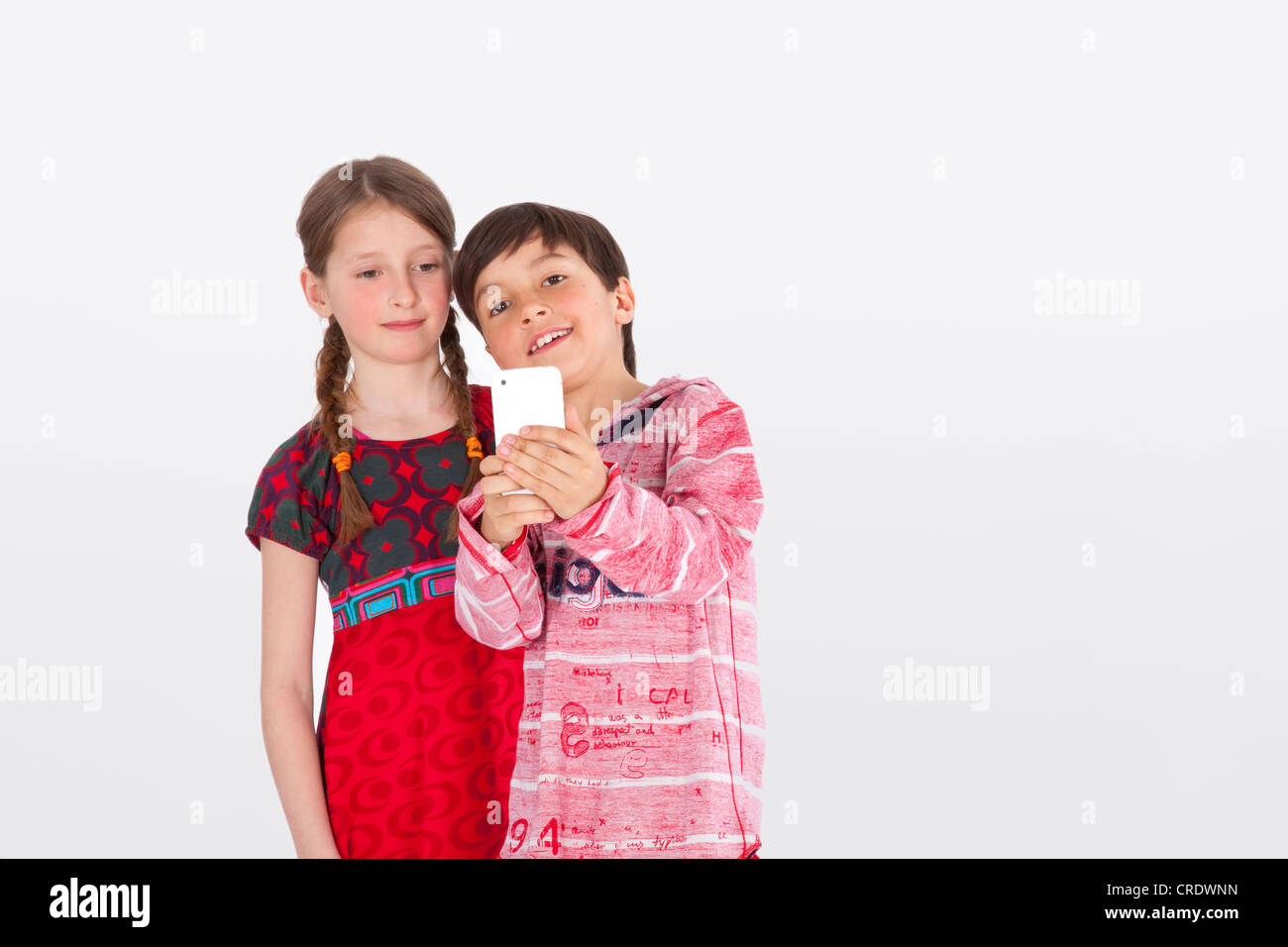 Girl and boy, 9 years, with mobile phone Stock Photo