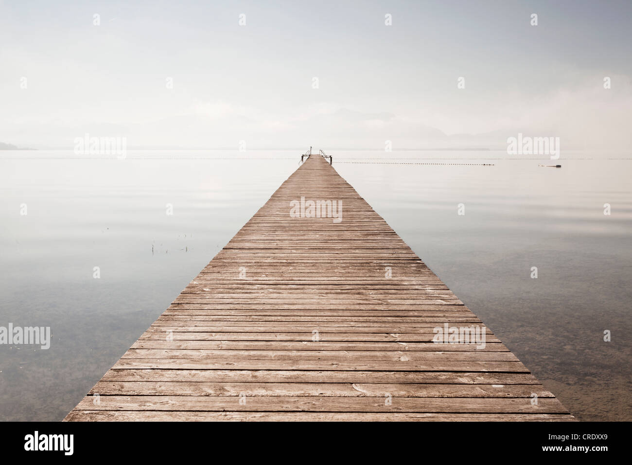 Very long jetty at Chiemsee Lake during high fog and sunshine near Seebruck, Bavaria, Germany, Europe, PublicGround Stock Photo