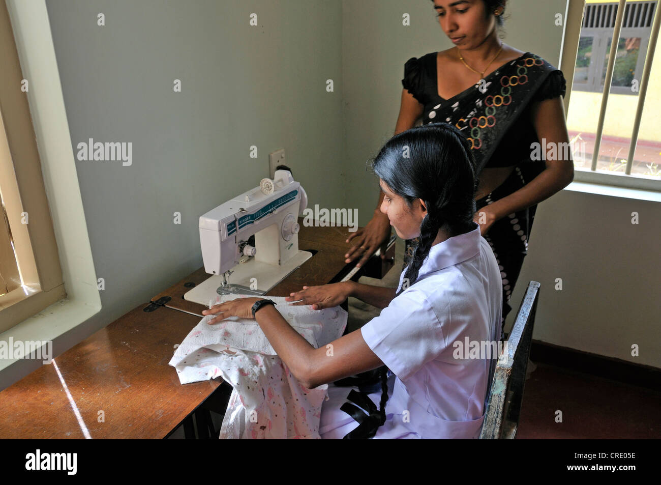 Girl, pupil, education at a sewing machine, school for the deaf