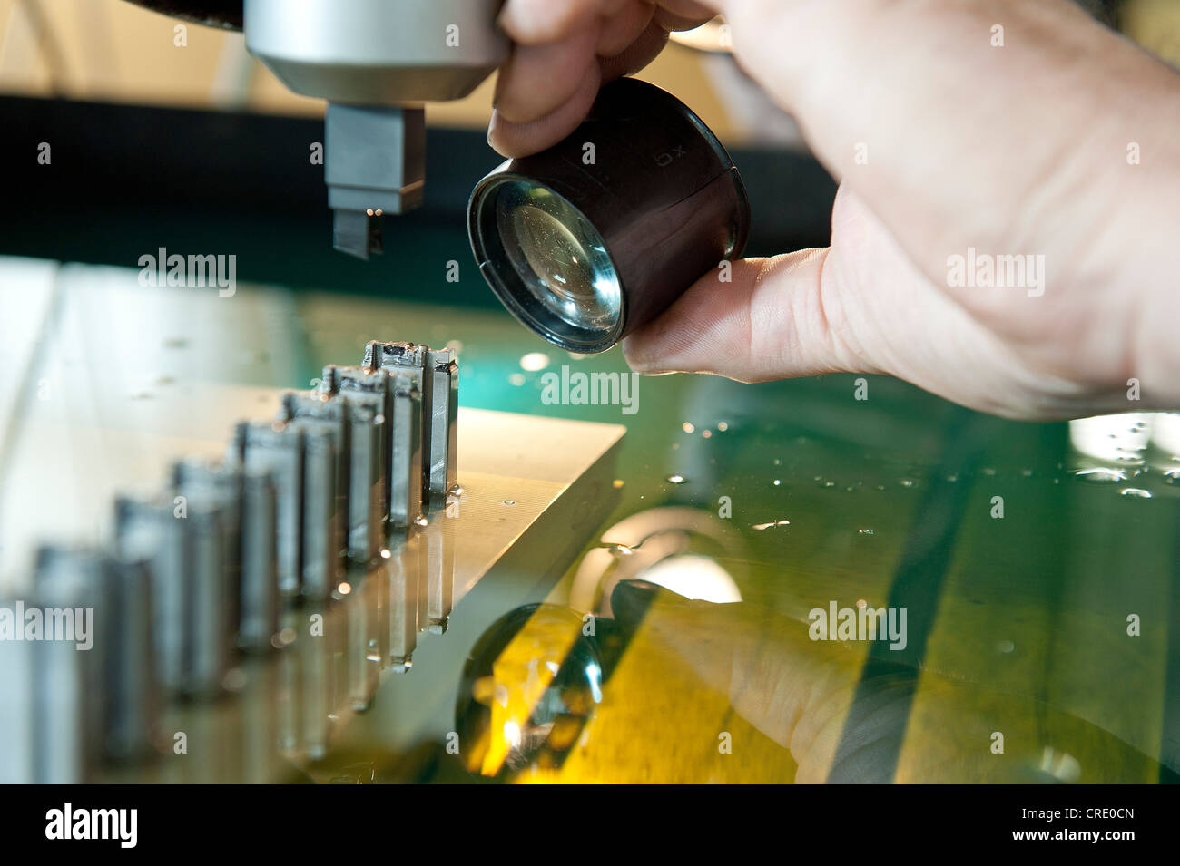 Electric discharge machine, eroding small pieces, work being checked with a loupe, design and construction for plastic injection Stock Photo