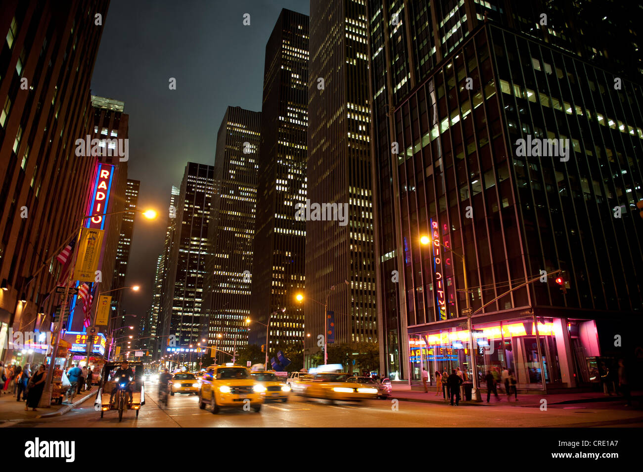 Illuminated skyscrapers and traffic at night, 6th Avenue corner of 51st West, Midtown, Manhattan, New York City, USA Stock Photo