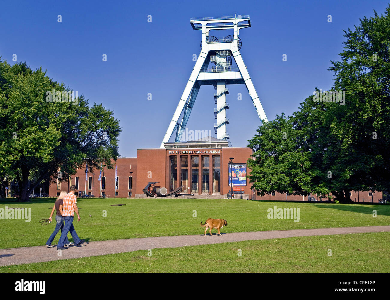 a couple walking with the dog in front of the German Mining Museum, Germany, North Rhine-Westphalia, Ruhr Area, Bochum Stock Photo