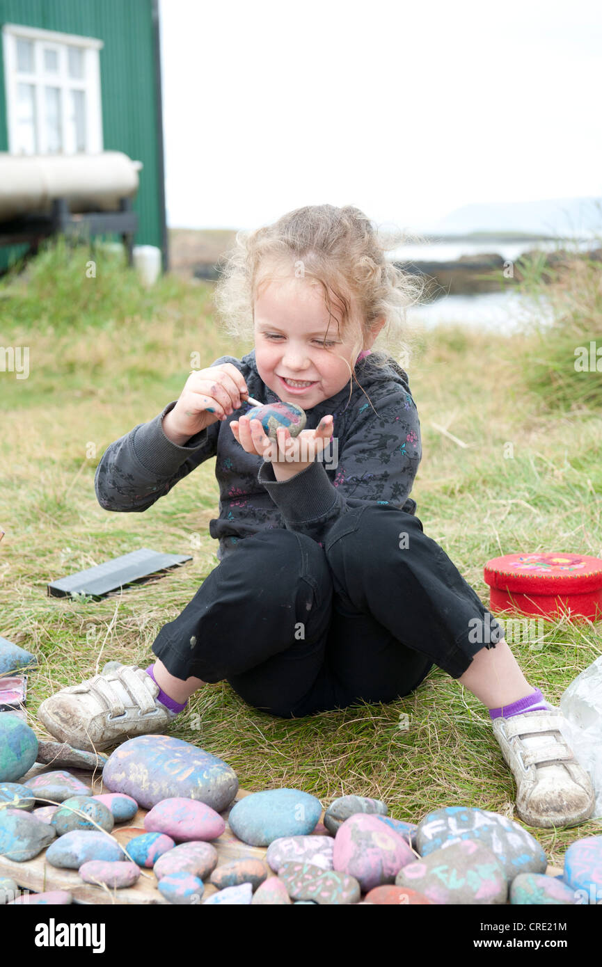 Girl colouring stones, Flatey, Iceland, Scandinavia, Northern Europe, Europe Stock Photo