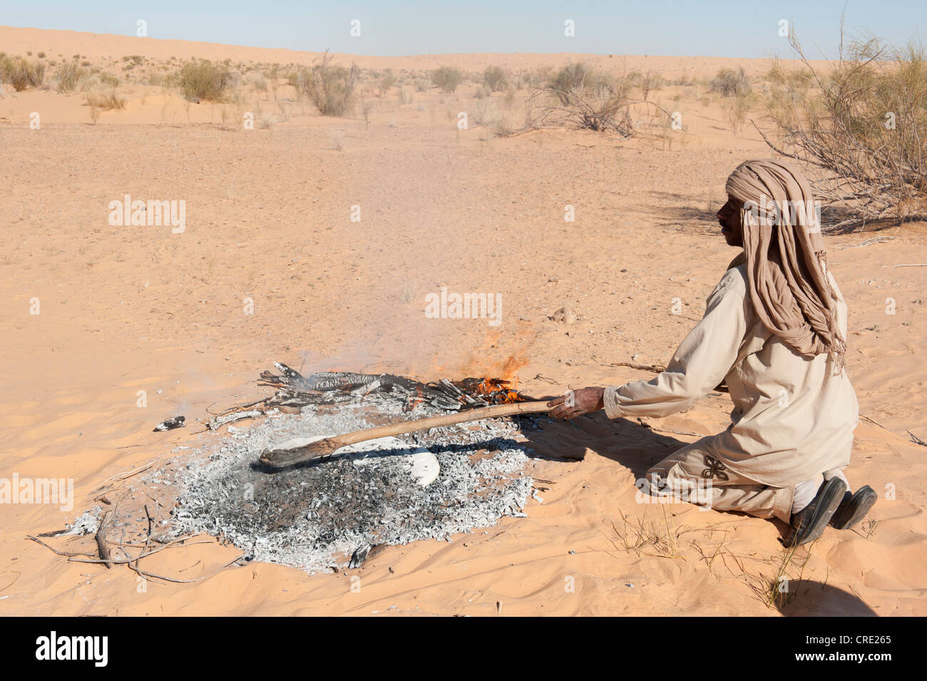Bedouin baking sand bread, pita bread, sand dunes, Sahara desert between Douz and Ksar Ghilane, Southern Tunisia, Tunisia Stock Photo