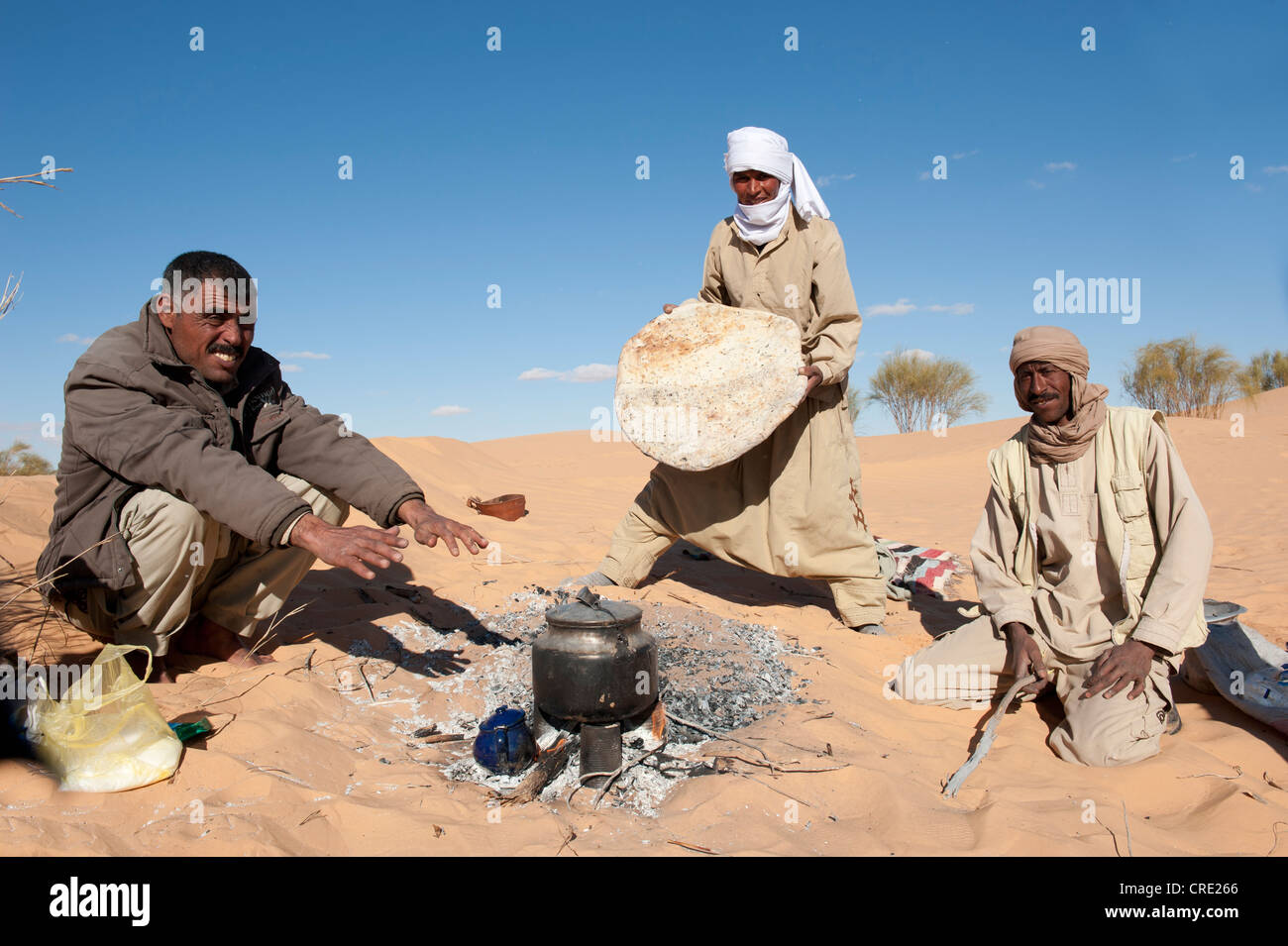 Bedouin baking sand bread, pita bread, sand dunes, Sahara desert between Douz and Ksar Ghilane, Southern Tunisia, Tunisia Stock Photo