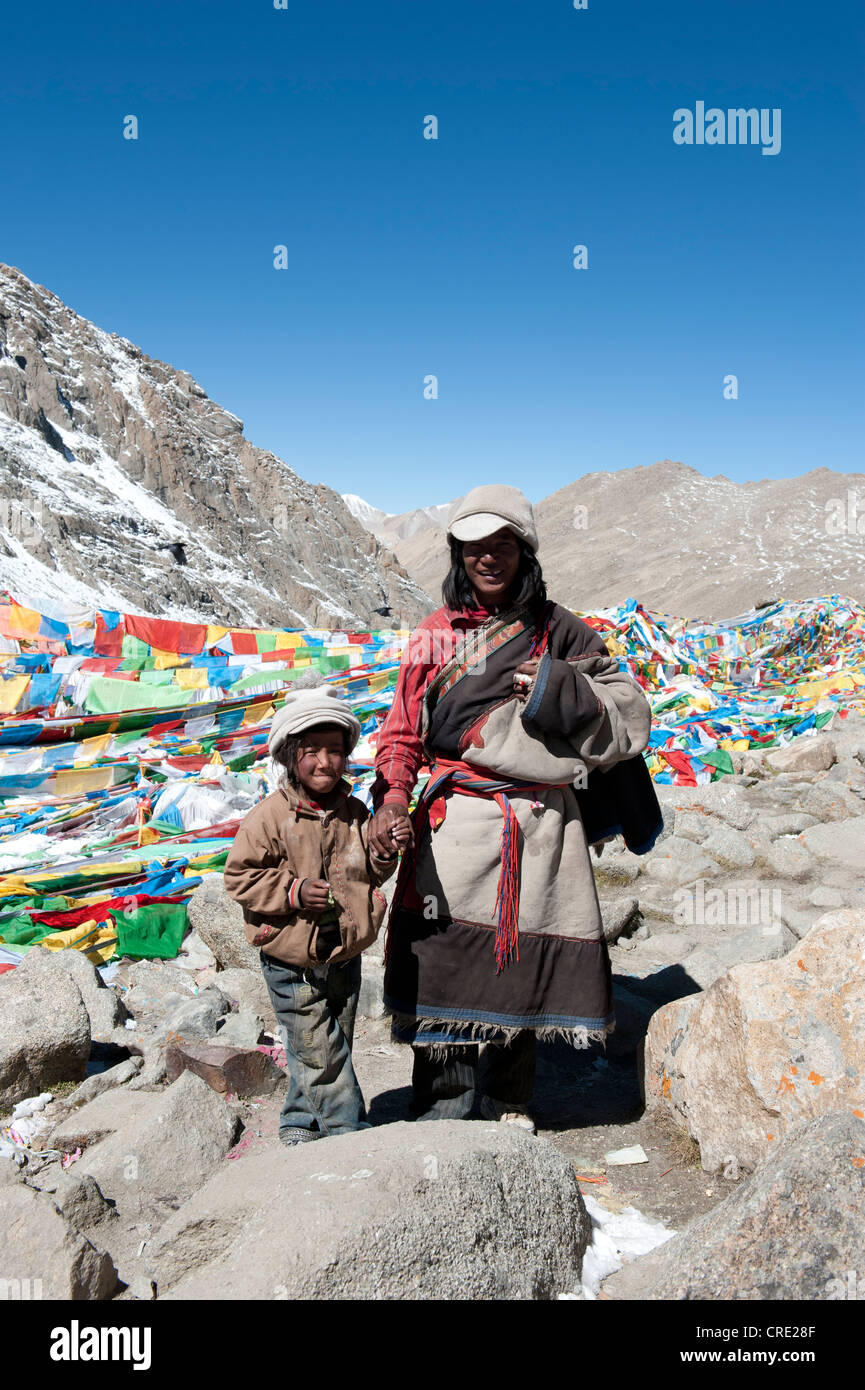 Tibetan Buddhist, pilgrims at the Dolma La Pass, 5670 m, colorful prayer flags, father and son, pilgrimage route around the Stock Photo