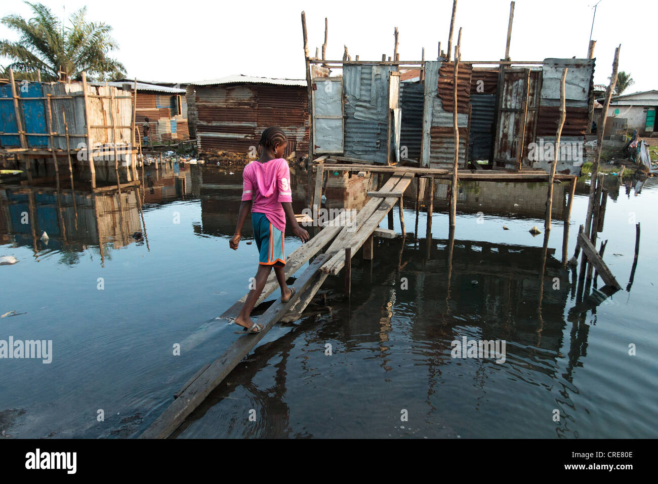 A girl walks up to a latrine on stilts in the Clara town slum in Monrovia, Montserrado county, Liberia on Thursday April 5, 2012 Stock Photo