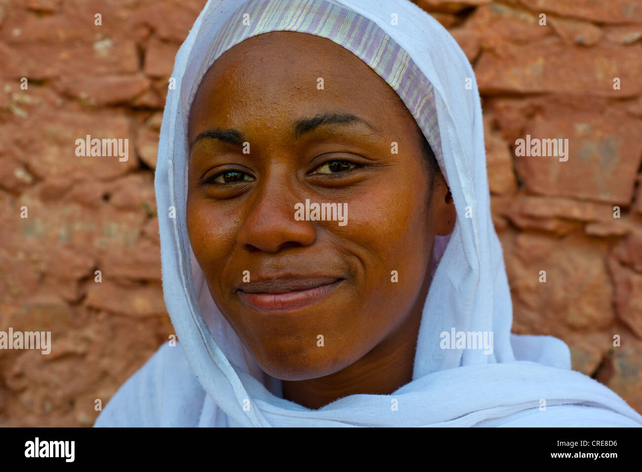 Portrait of a smiling, dark-skinned, young woman wearing a white headscarf, southern Morocco, Morocco, Africa Stock Photo