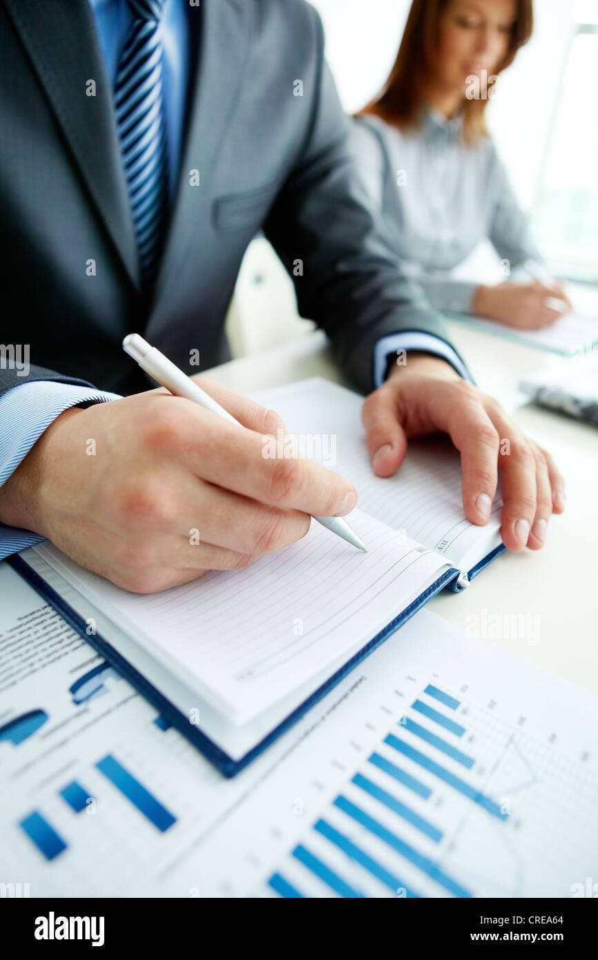 Vertical shot of business people making notes at conference Stock Photo ...