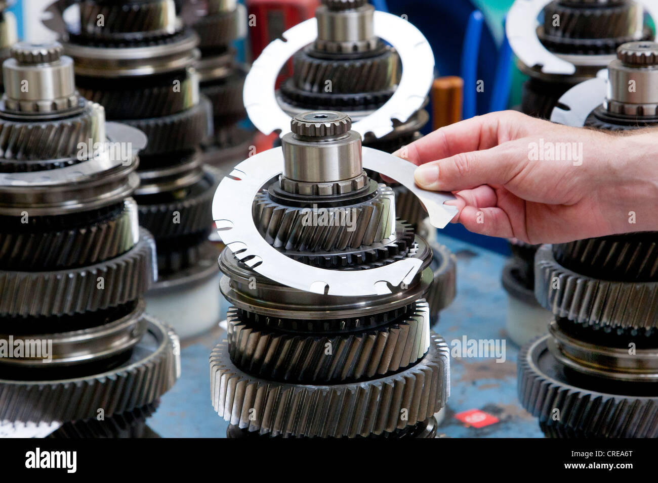 Placing a spacer onto a gearbox main shaft in the tractor production section at the European headquarters of the American Stock Photo