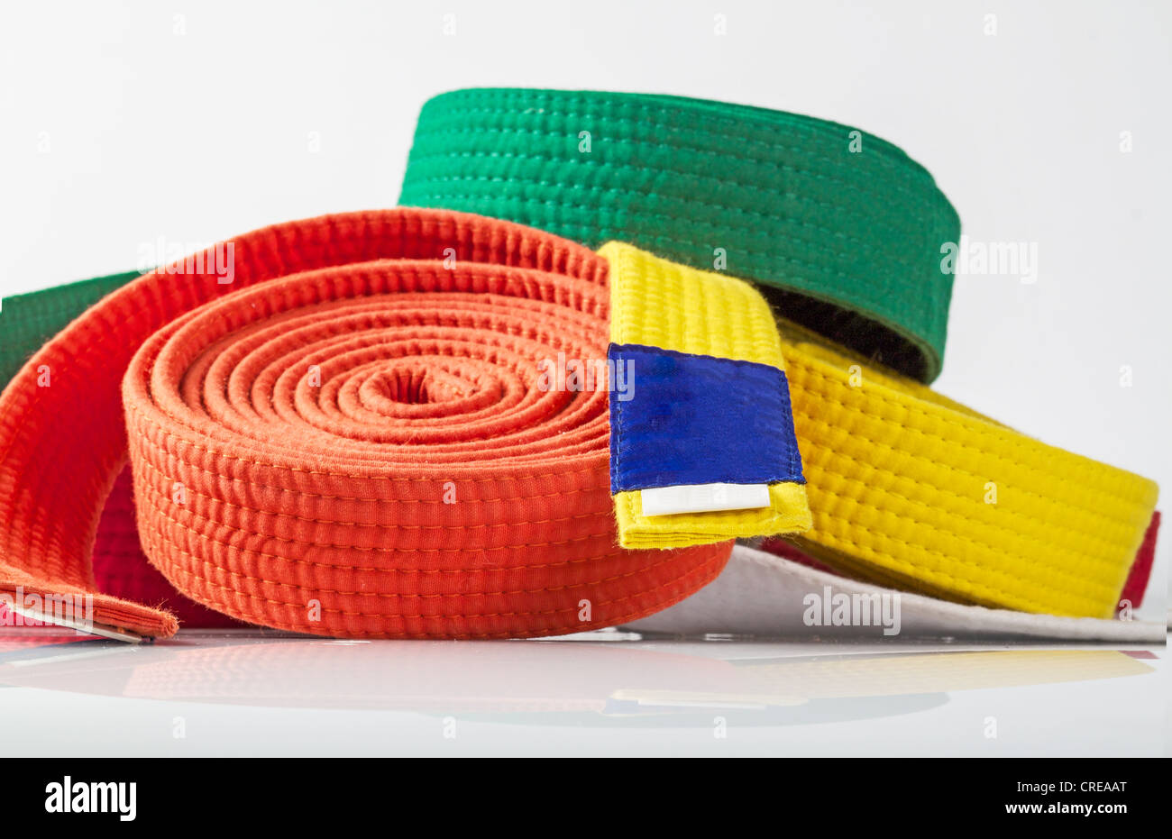 A collections of Karate belts agaist a white background Stock Photo