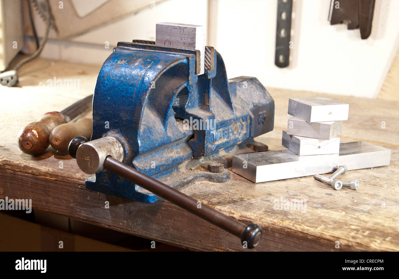 Vice With A Block Of Metal On A Wooden Workbench Stock Photo