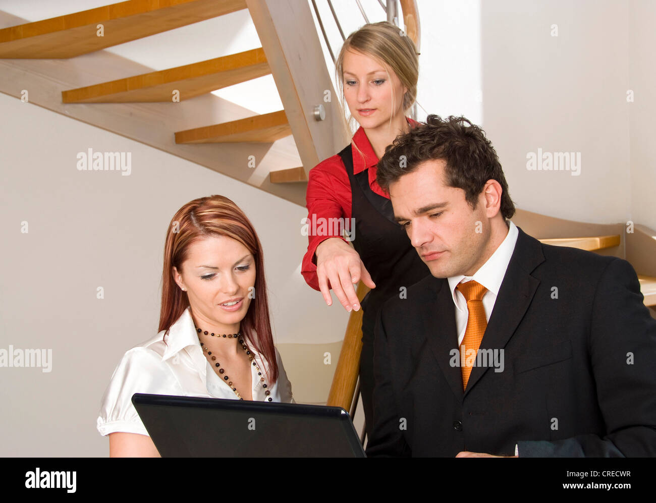 three young business people with laptop Stock Photo - Alamy