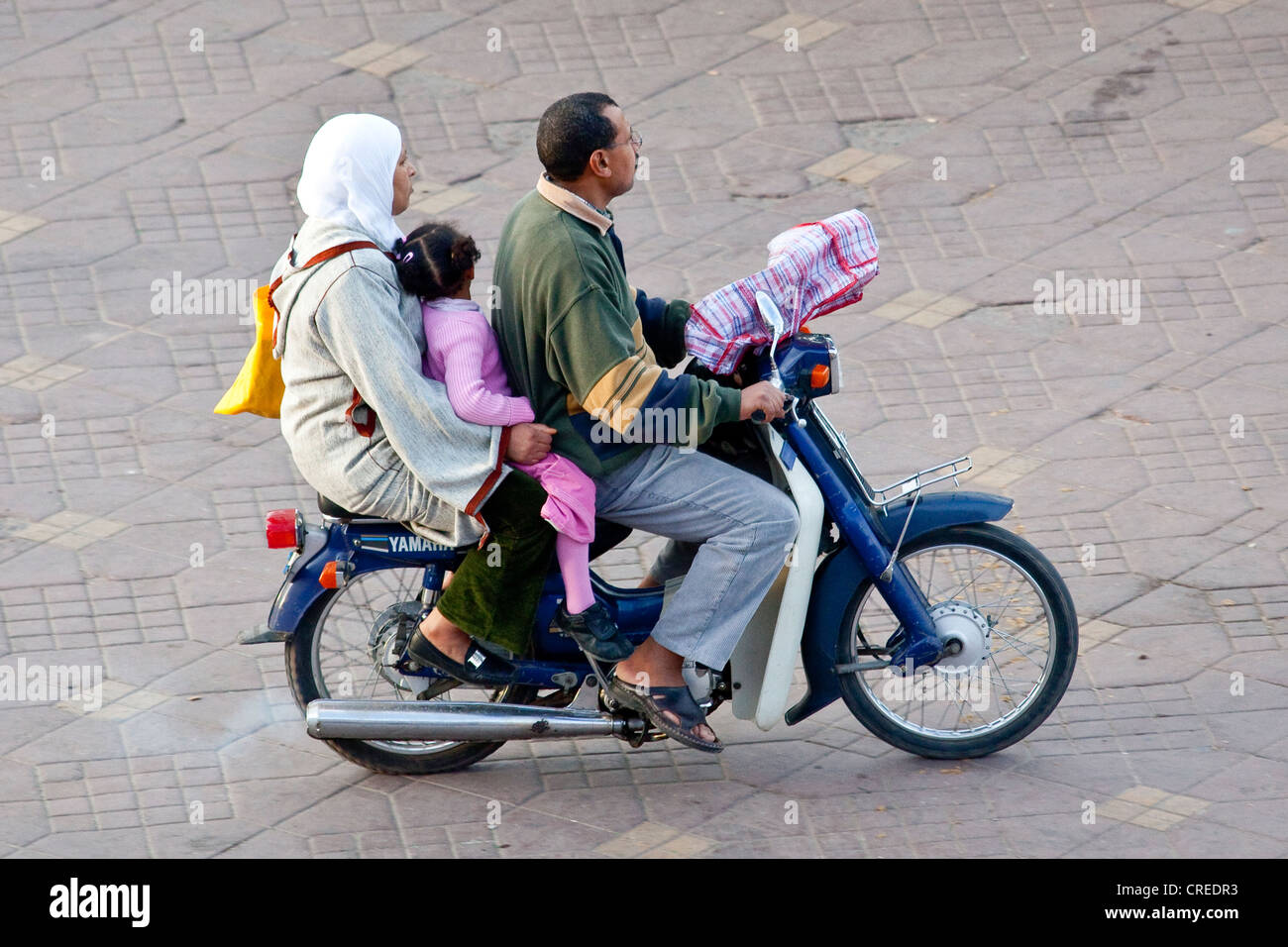 Family riding a moped in Djemaa el Fna square, medina or old town, UNESCO World Heritage Site, Marrakech, Morocco, Africa Stock Photo