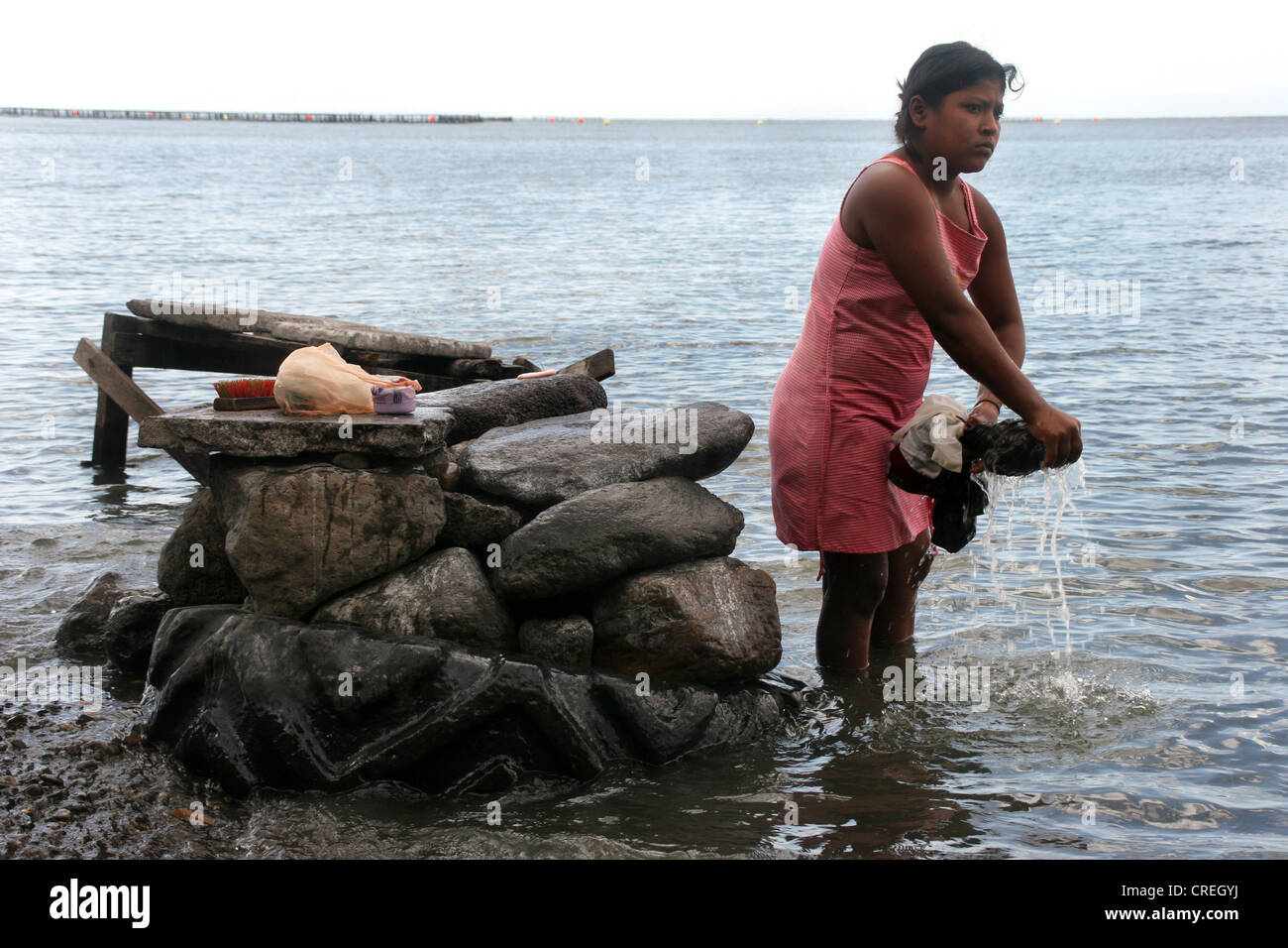 women washes clothes on a stone block in Lake Nicaragua, Nicaragua, Nicaragua See Stock Photo