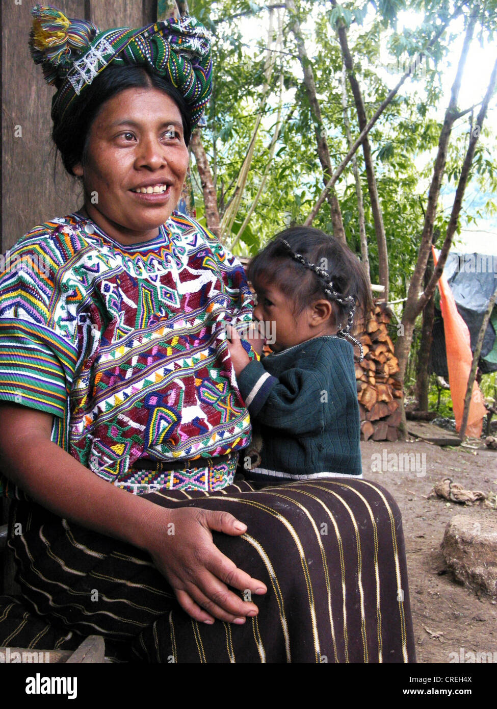 Mayan woman in traditional clothing and nursing a child in a village close to Nebaj, Guatemala, Quich�, Nebaj Stock Photo