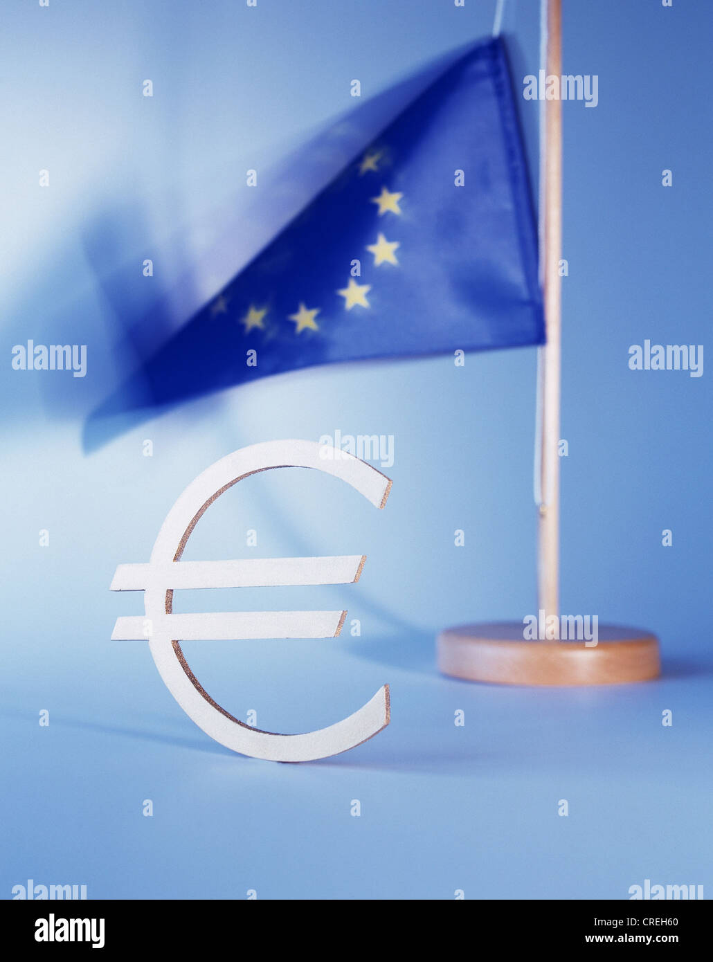 The euro sign standing in front of an EU flag Stock Photo