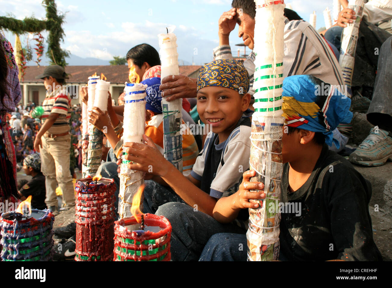 Mayan children with big candles in the middle of a Maya procession in Santiago de Atitlan, Guatemala, Atitlansee, Santiago de Atitlan Stock Photo