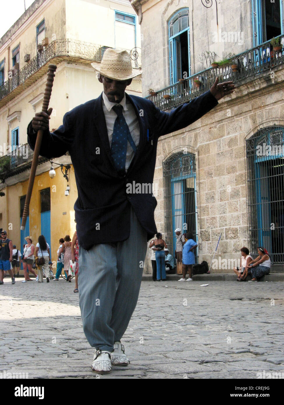 man dancing in the streets of  the old town, with stick, hat and cigar, Cuba, La Habana Stock Photo