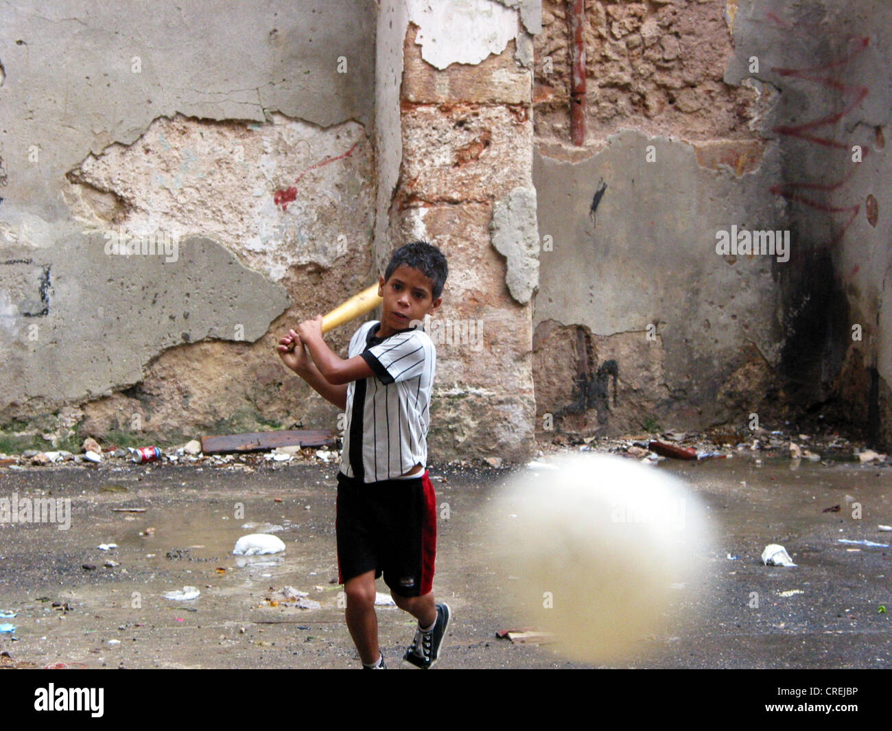 boy playing baseball in a backyard in the old town, Cuba, La Habana Stock Photo