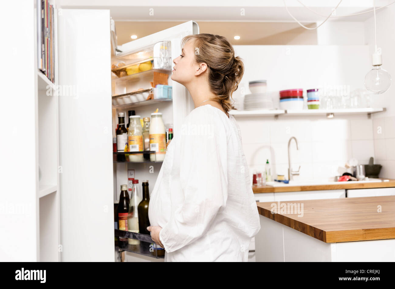 Pregnant woman searching fridge for food Stock Photo Alamy
