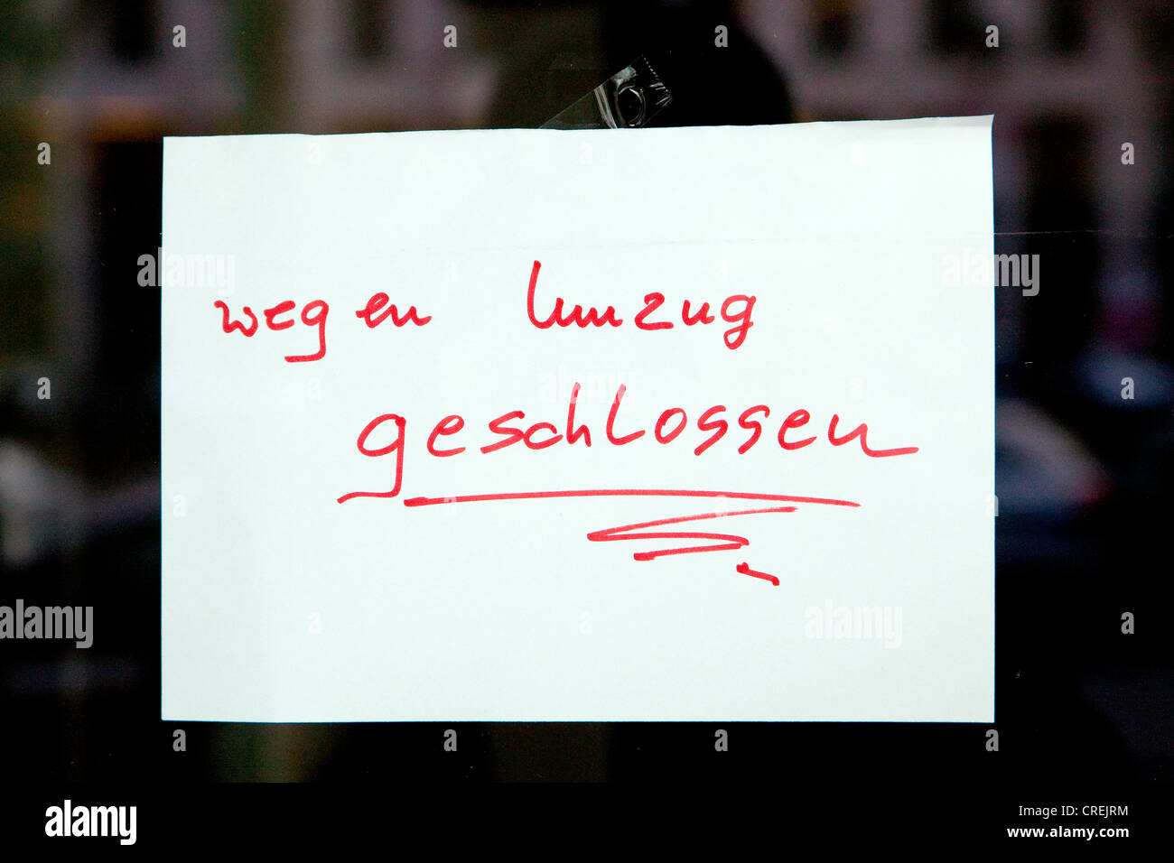 Handwritten sign on a shopwindow, lettering 'wegen Umzug geschlossen', German for 'Closed due to relocation' Stock Photo