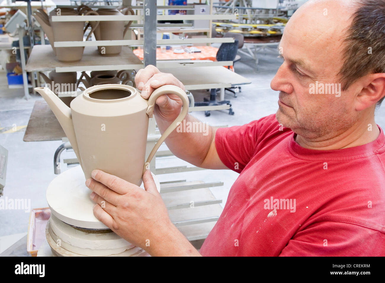 Employees attaching a handle, coffee pot from Hutschenreuther, in the production of tableware at the porcelain manufacturer Stock Photo
