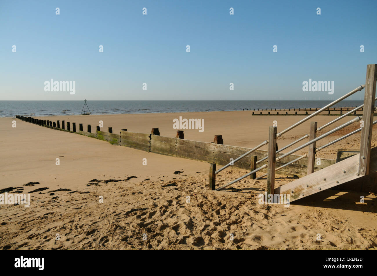 Hardwood timber steps to the beach, and the sandy beaches of Frinton Essex Stock Photo