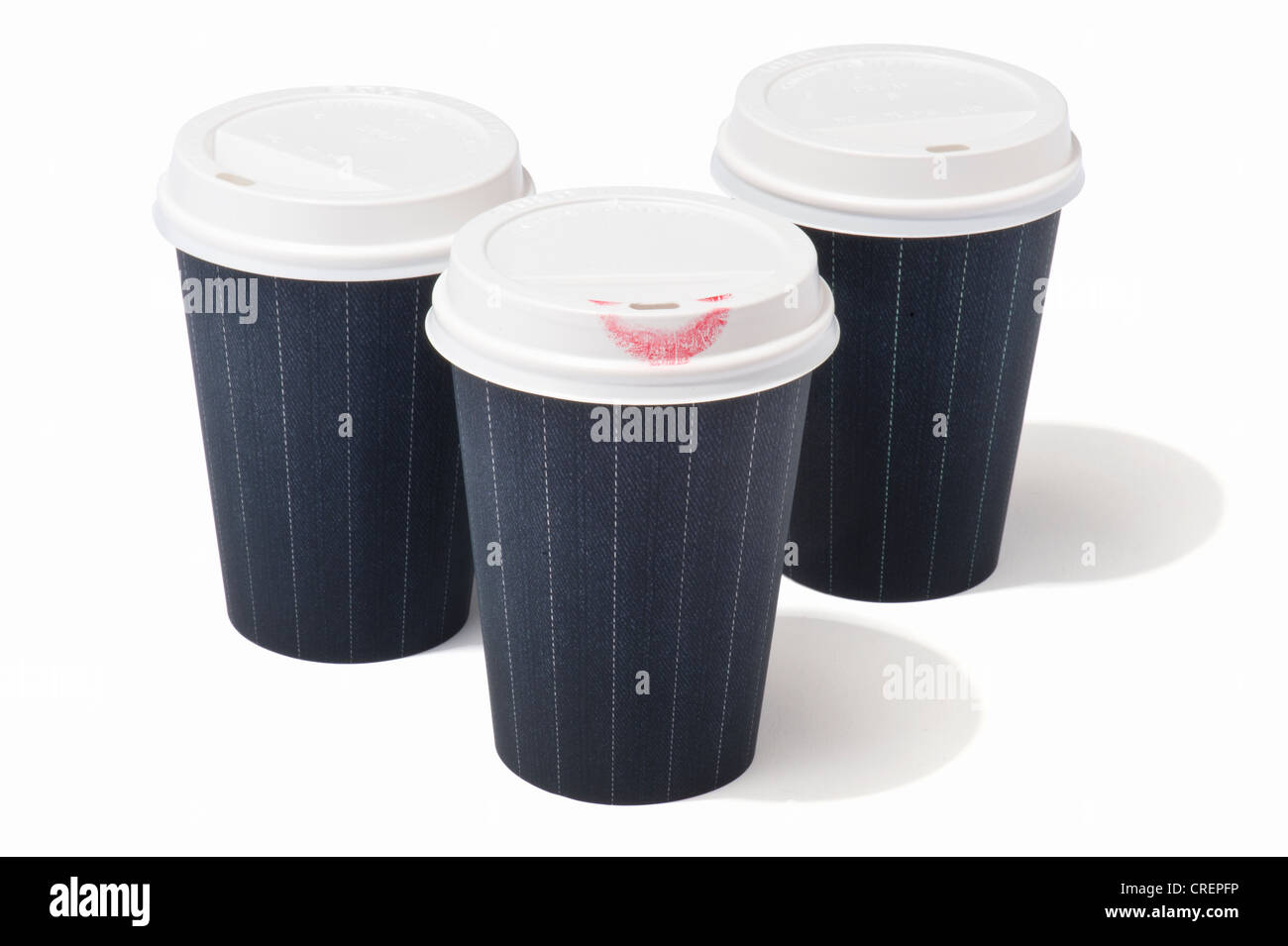 Three takeaway drink cups with pinstripe pattern, one with a lipstick mark Stock Photo