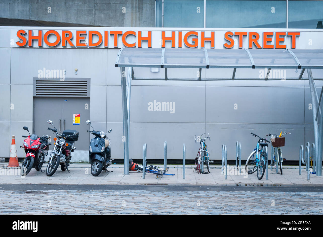 London East End Brick Lane area motor bikes bicycles cycles stand park parking by Shoreditch High Street tfl Overground station sign signs Stock Photo
