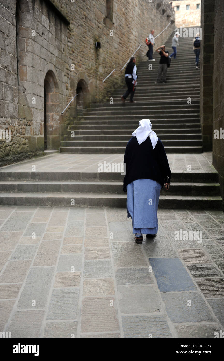 Back view of a nun at Mont Saint Michel Stock Photo