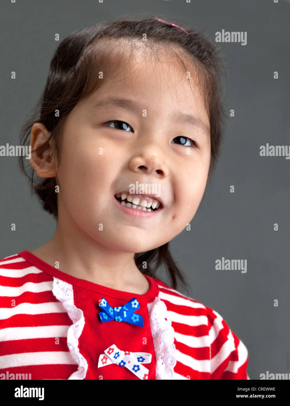 Head and shoulders portrait of happy, smiling 4year old Chinese girl in ...