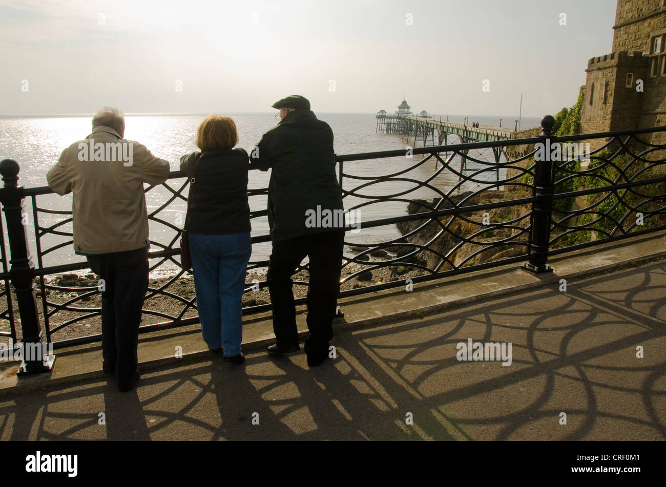 Three people looking at Clevedon Pier, Promenade, Clevedon, Somerset, United Kingdom, Europe Stock Photo